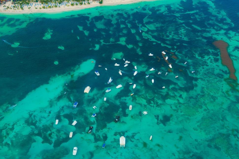 Free Image of Aerial view of boats and coral reefs in clear blue ocean waters 