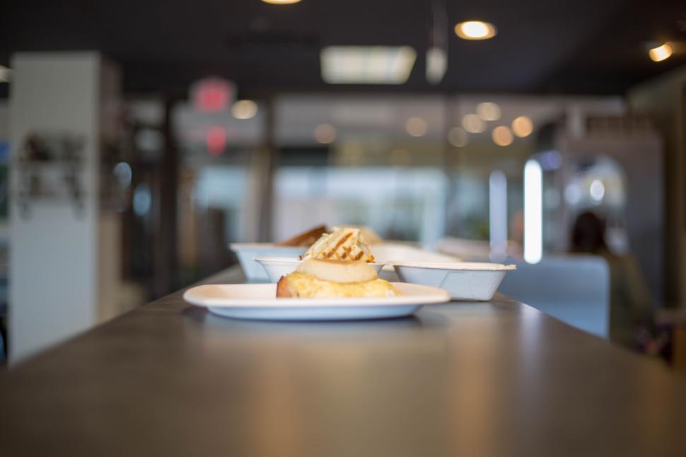Free Image of Desserts on plates displayed on a counter in a well-lit interior. 
