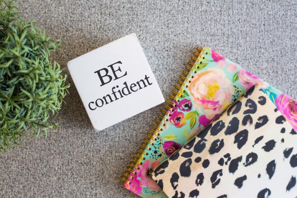 Free Image of Inspirational setup with decorative items and a  BE confident  block. 