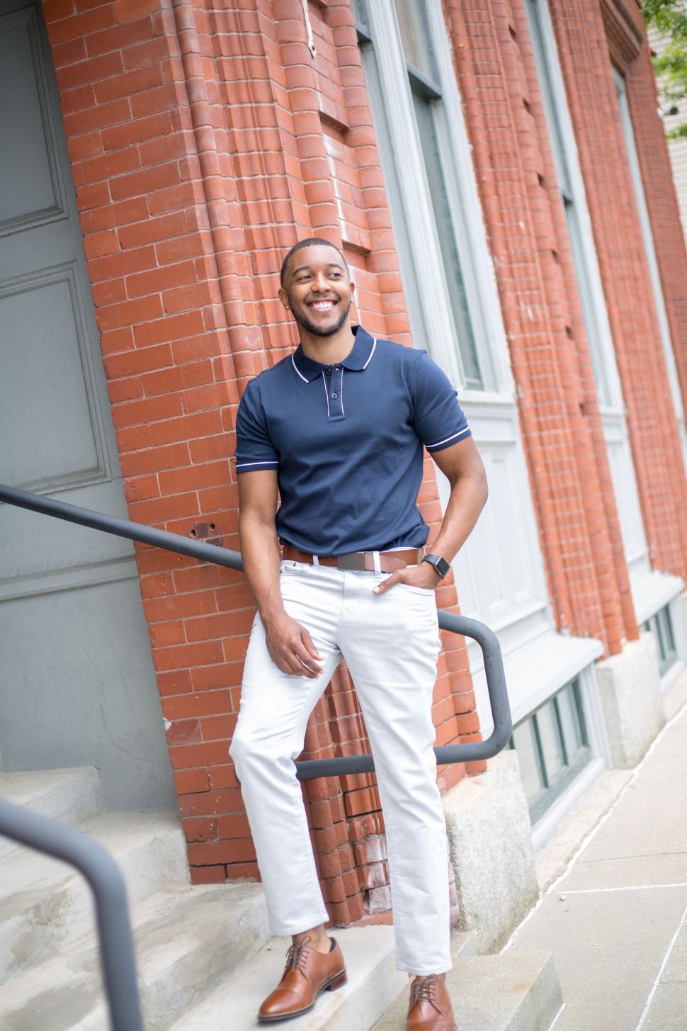 Free Stock Photo of Man posing outdoors against brick building in business casual. Download Free Images and Free Illustrations