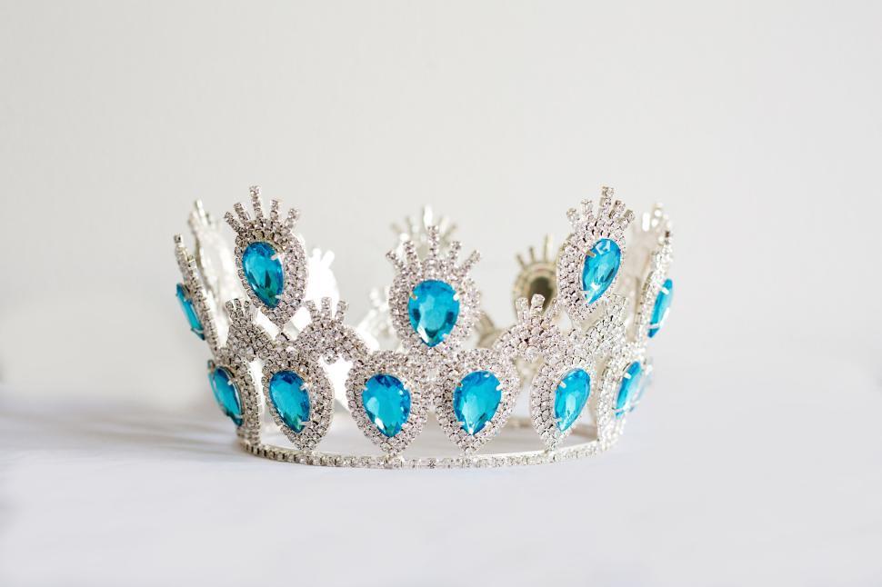 Free Image of Elegant silver crown adorned with blue gemstones on white surface 