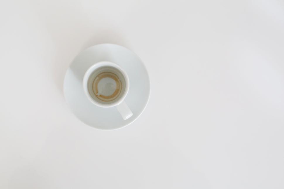 Free Image of White espresso cup with saucer showing coffee remnants view 