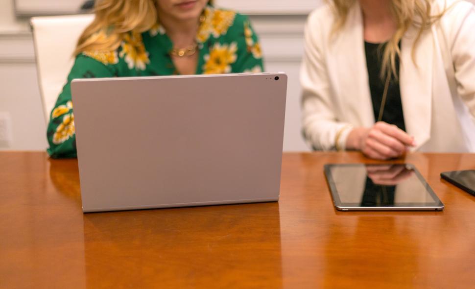 Free Image of Two women using a laptop and discussing work in office meeting 
