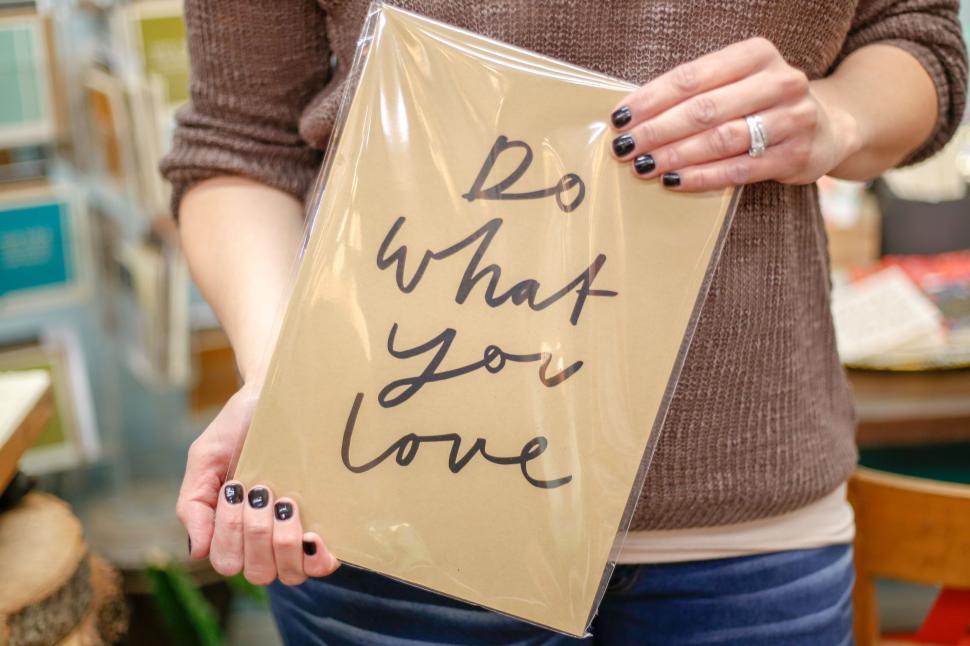 Free Image of Person holding framed  Do What You Love  print in plastic cover 