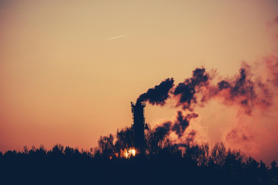 Free Image of Industrial chimney with smoke against a sunset background, nature view. 