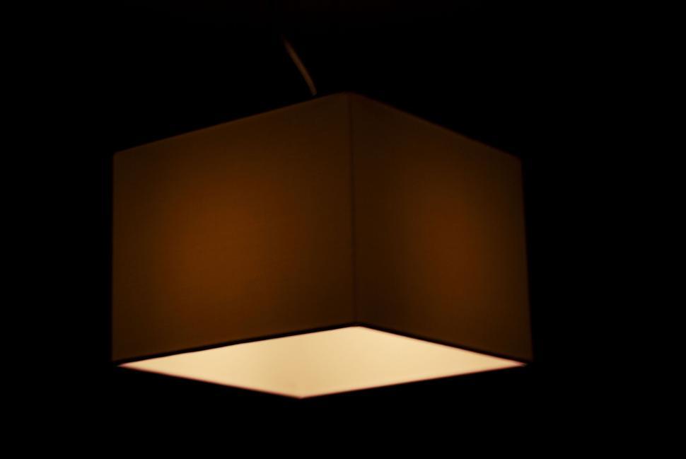 Free Image of A glowing rectangular ceiling lamp illuminating a dark room space 