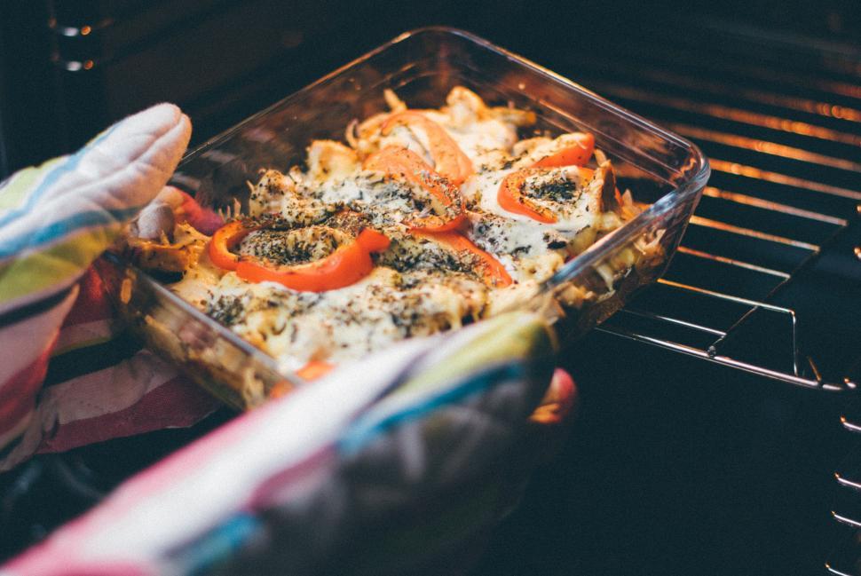 Free Image of Colorful oven-baked dish with peppers and cheese in clear glass pan. 