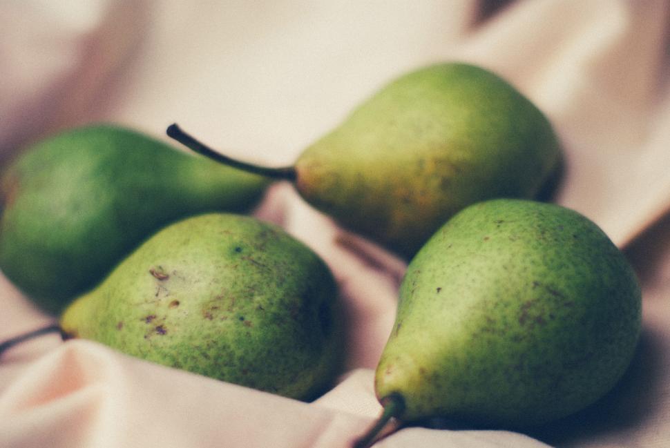 Free Image of Four green pears on light fabric capture ripe freshness and simplicity 
