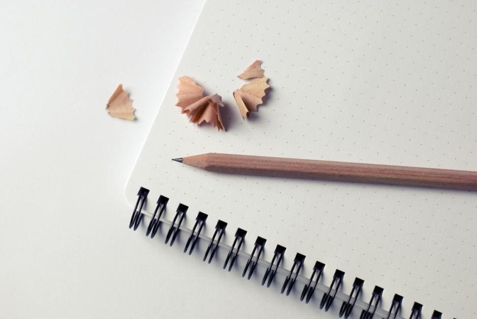 Free Image of Graphite pencil resting on a dotted notebook with shavings. 