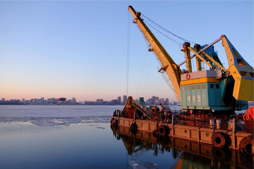 Free Image of Industrial crane on a barge at the harbor during sunset hours 