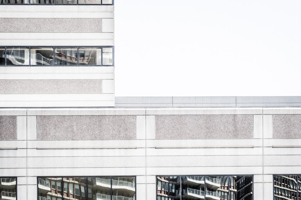 Free Image of Modern urban building facade with geometric patterns and windows. 