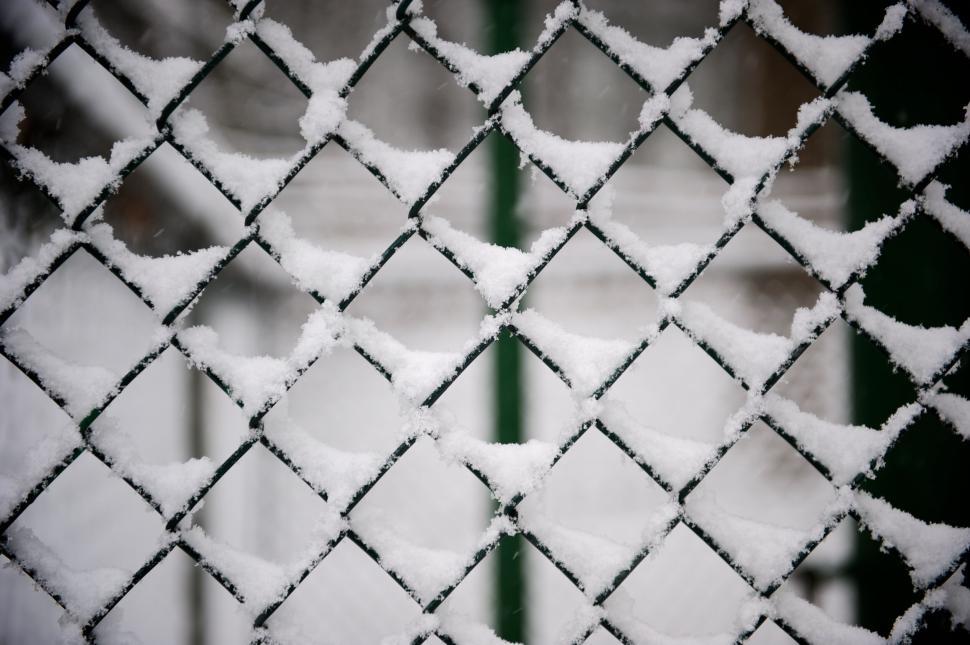 Free Image of Snow covered chain link fence with blurred background outdoors 