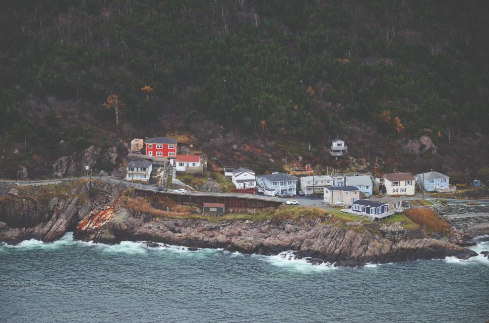 Free Image of Coastal village with colorful houses beside a rocky shoreline. 