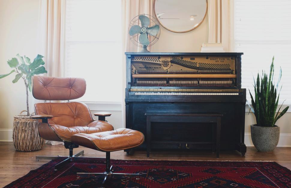 Free Image of Elegant living room with brown chair, plant, and vintage piano 