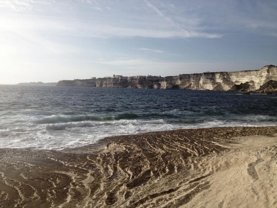 Free Image of Scenic coastal view of waves crashing against a rocky shoreline. 