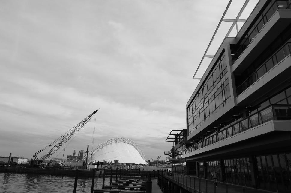 Free Image of Modern waterfront architecture beside a harbor under a cloudy sky 