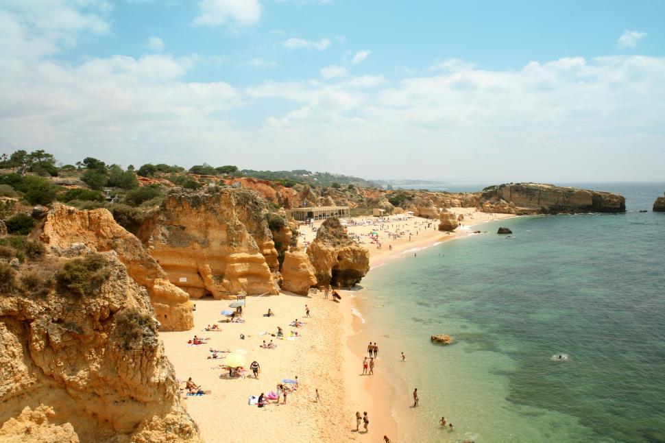 Free Image of Vast beach with crystal clear waters and scenic rock formations. 