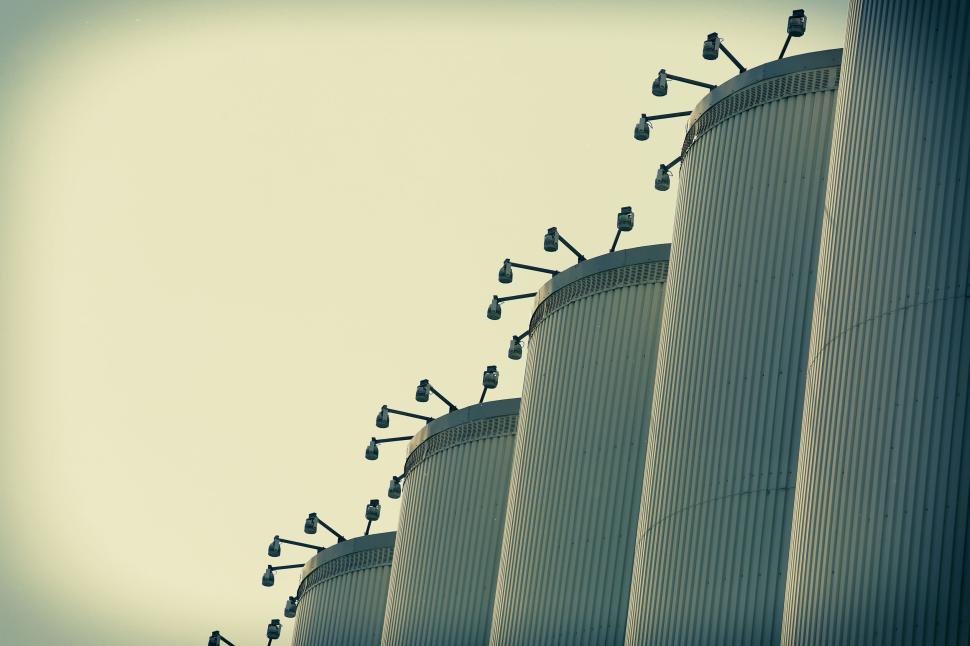 Free Image of Row of grain silos with surveillance cameras mounted on top 