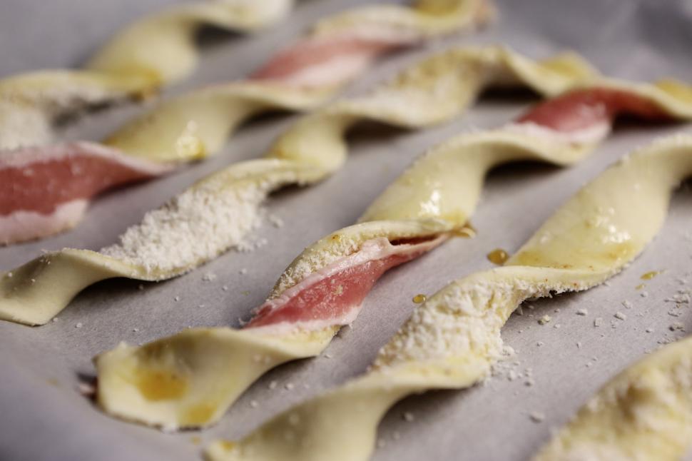 Free Image of Bacon and cheese twist pastries on baking sheet lined with parchment. 
