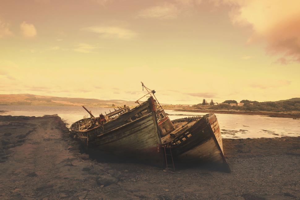 Free Image of Sunset-tinged Abandoned Ships on a Rocky Shoreline by the Sea 