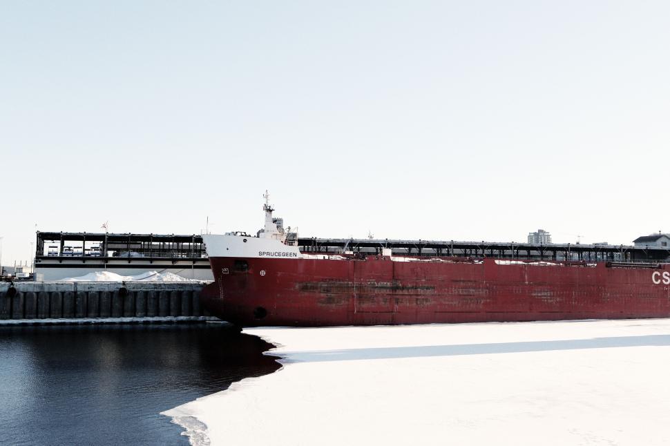 Free Image of Large Red Cargo Ship Docked at an Industrial Harbor in Winter 
