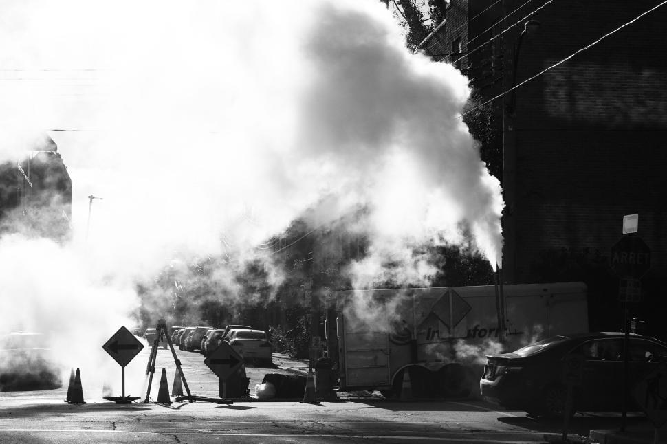 Free Image of Steam emerging from a structure, with industrial elements present. 