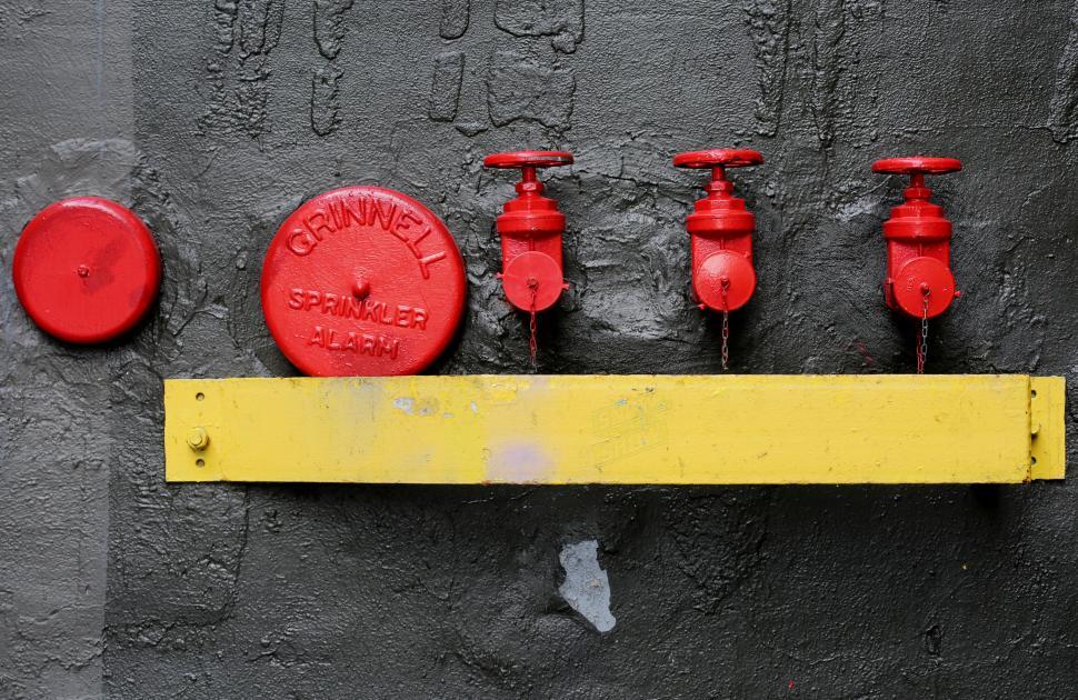 Free Image of Red Alarm Sprinkler System on Industrial Gray Wall Background 