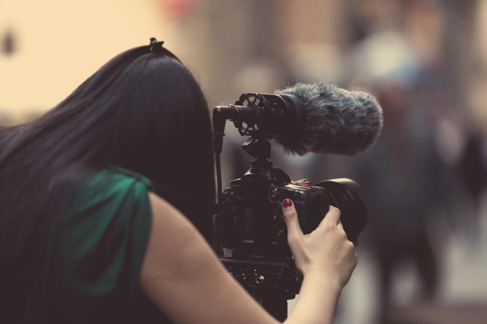 Free Image of Woman operating a professional camera with microphone outdoors. 