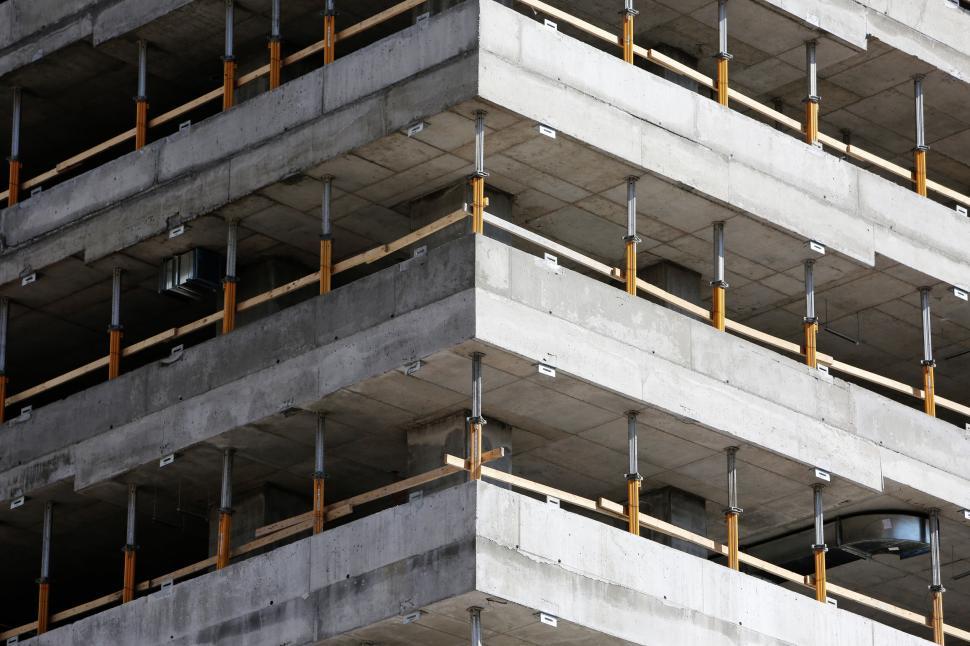 Free Image of Concrete multi-story building under construction with metal supports. 