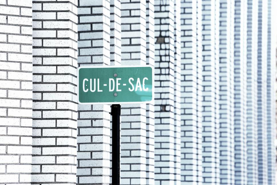 Free Image of Cul-de-sac street sign against a backdrop of patterned brick walls. 