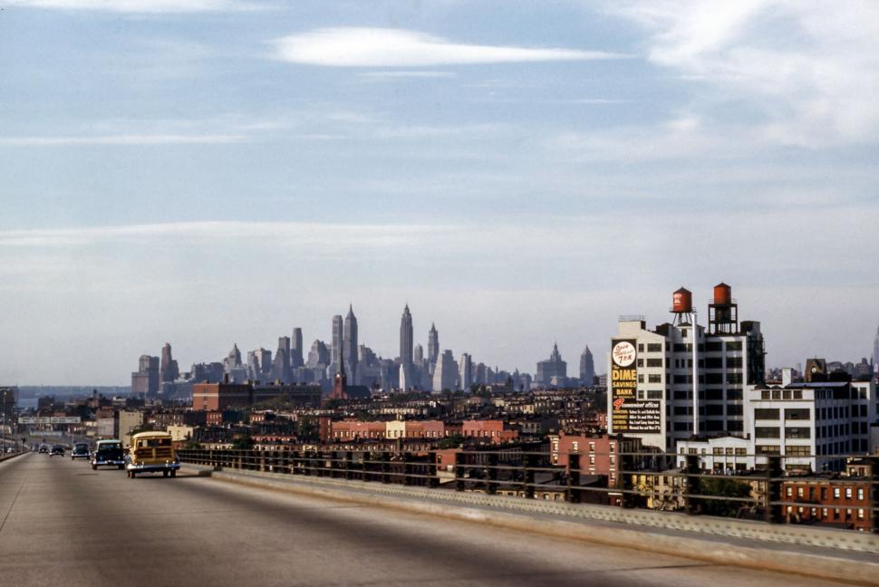 Free Image of View of city skyline with tall buildings from a highway bridge. 