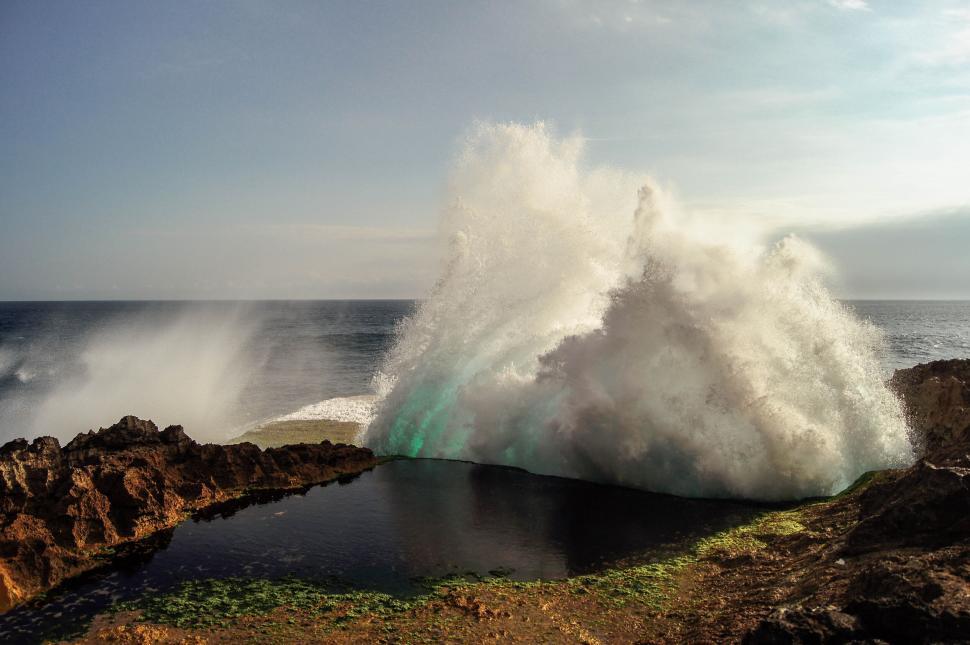 Free Image of Powerful ocean waves crashing against rocky shoreline majestically. 