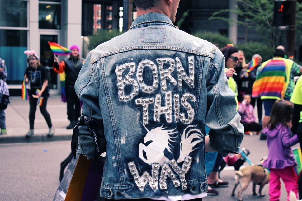 Free Image of Person in a denim jacket with  Born This Way  at a street event 