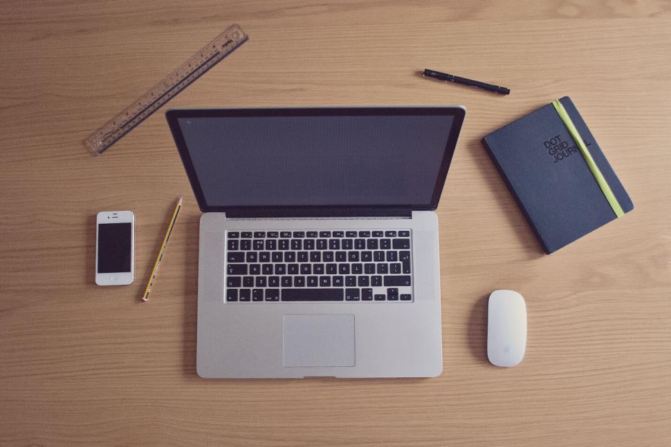 Free Image of Workspace with a laptop, phone, notebook, mouse, and ruler 