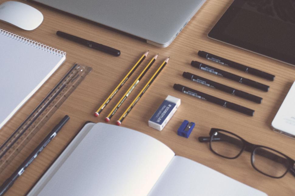 Free Image of Organized workspace with pencils, notebook, laptop and glasses 