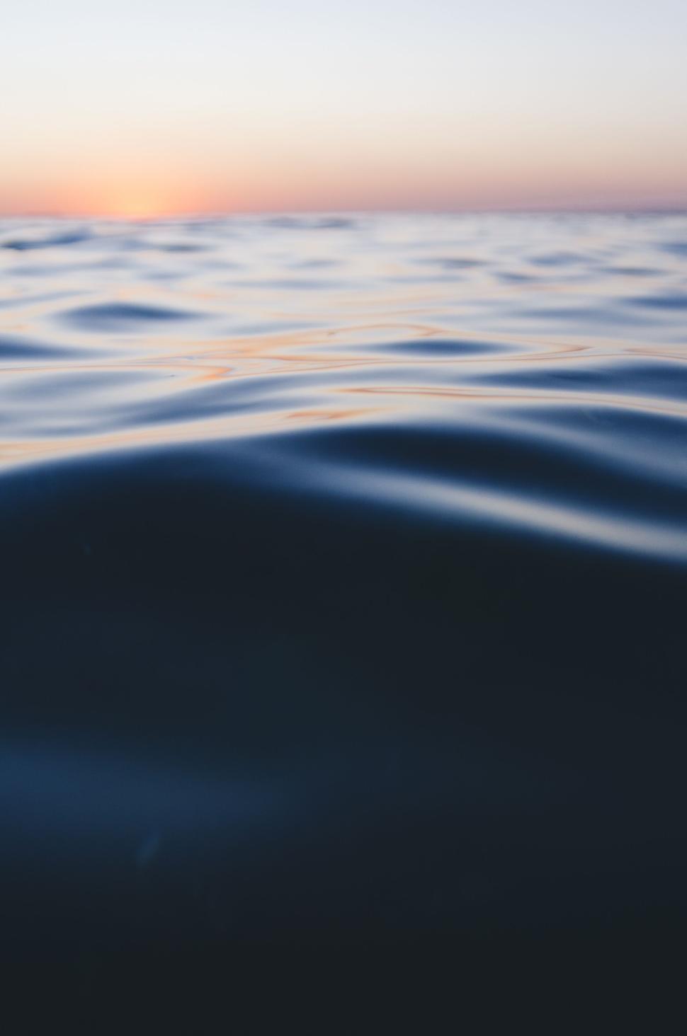 Free Image of Peaceful ocean waves during sunset with golden sky and horizon. 