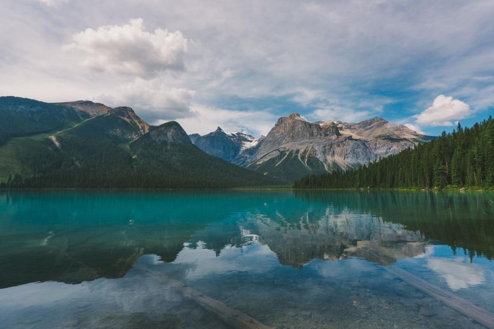 Free Image of Stunning turquoise lake reflecting grand mountains and clear skies. 