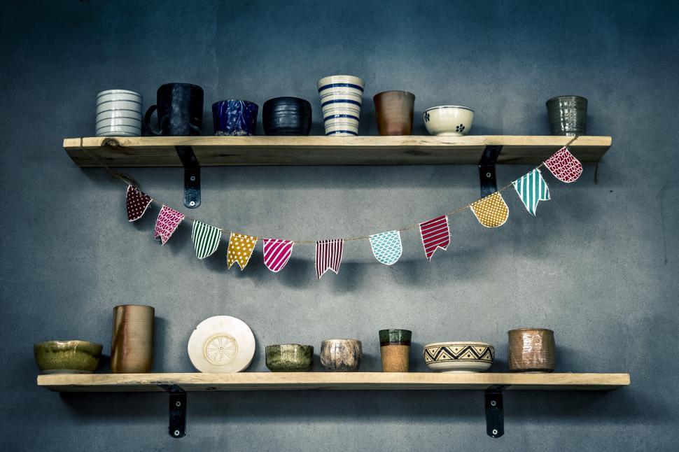 Free Image of Shelves with a variety of ceramic cups and bowls in artistic display 