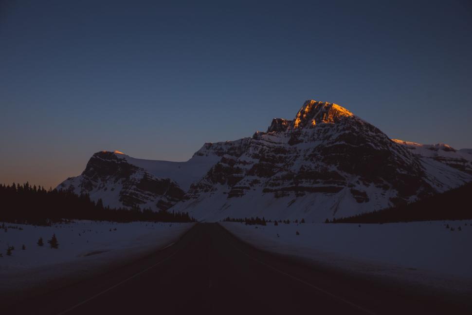 Free Image of Mountain peaks glowing with the last light of sunset against twilight sky. 