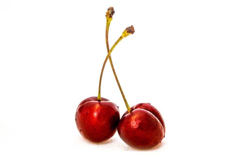 Free Image of Two red cherries with water droplets on white background for freshness 