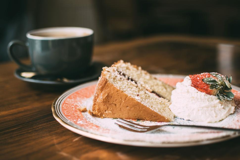 Free Image of Slice of cake with whipped cream and strawberry on a plate 