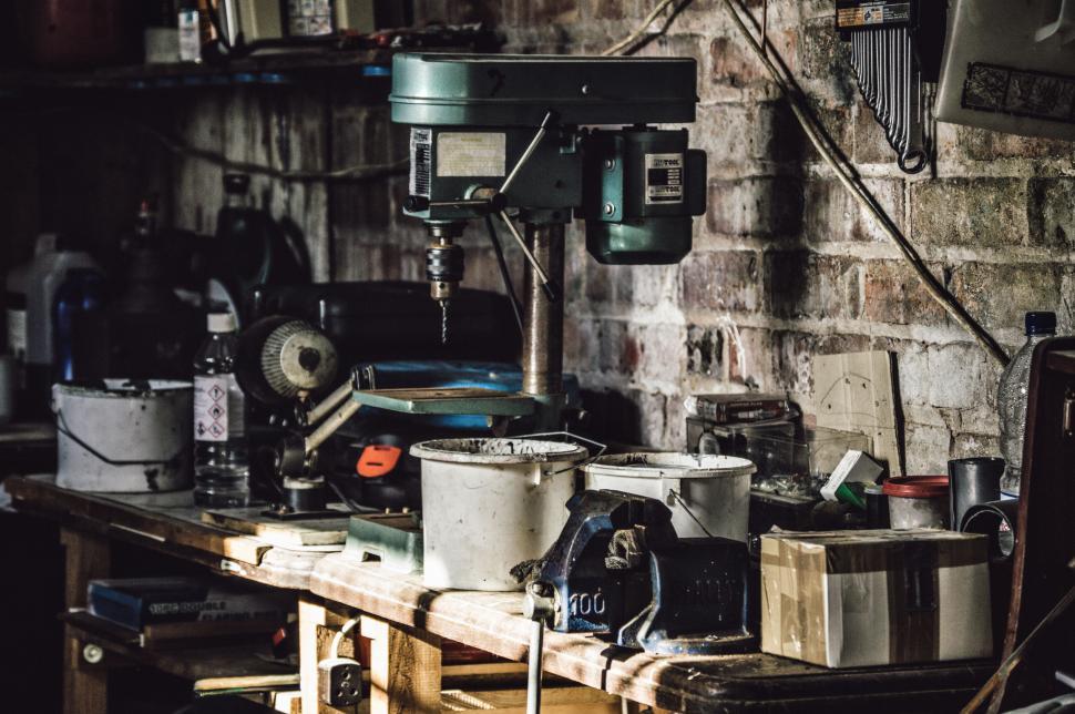 Free Image of Messy workshop with power tools on workbench in rustic setting 