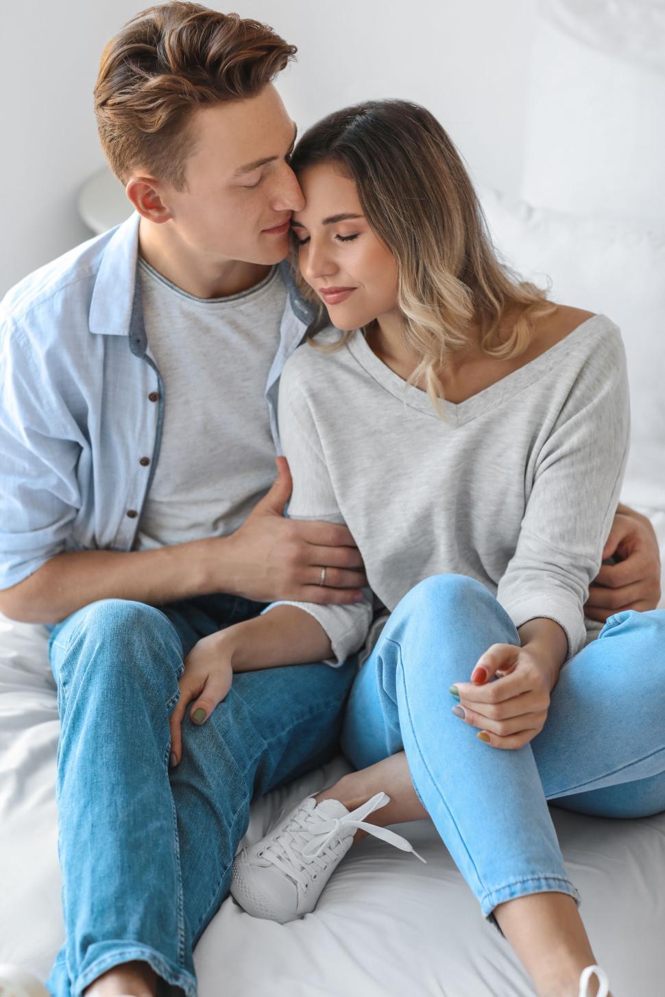 Free Image of Couple embracing on bed, sharing intimate moment, natural light. 