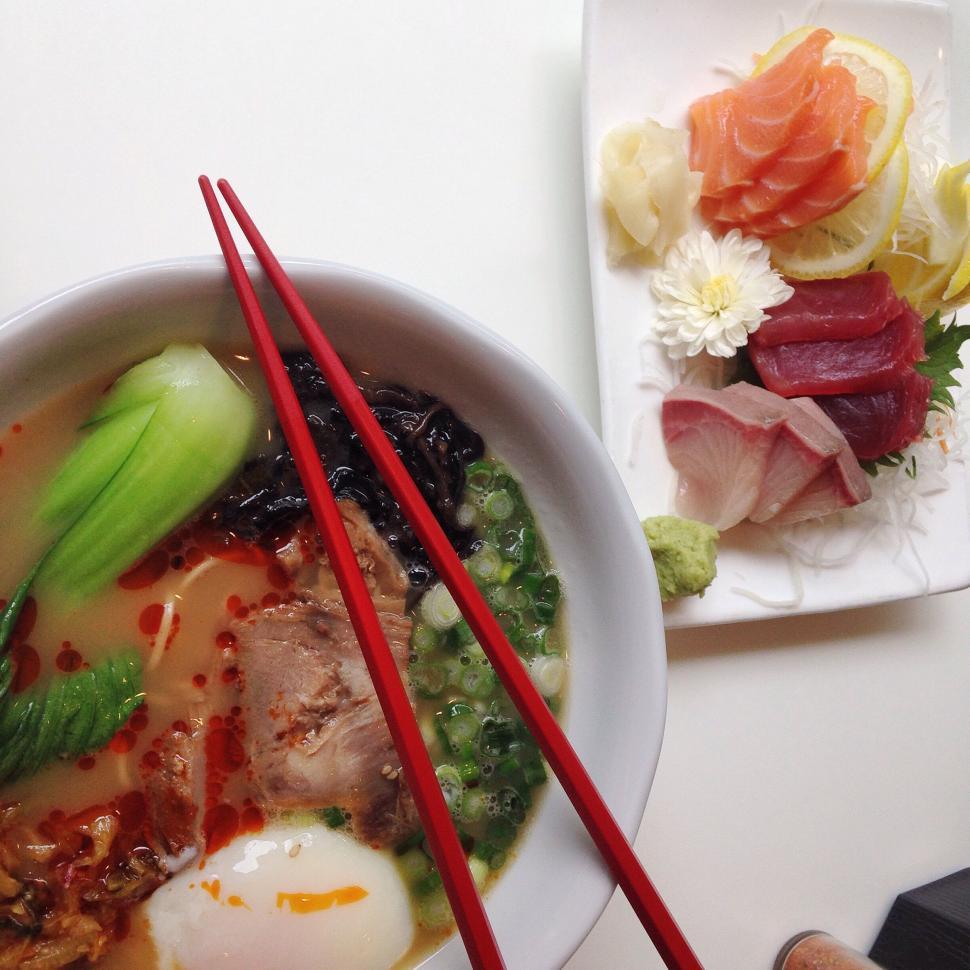 Free Image of Asian dish with ramen and sashimi served with red chopsticks 
