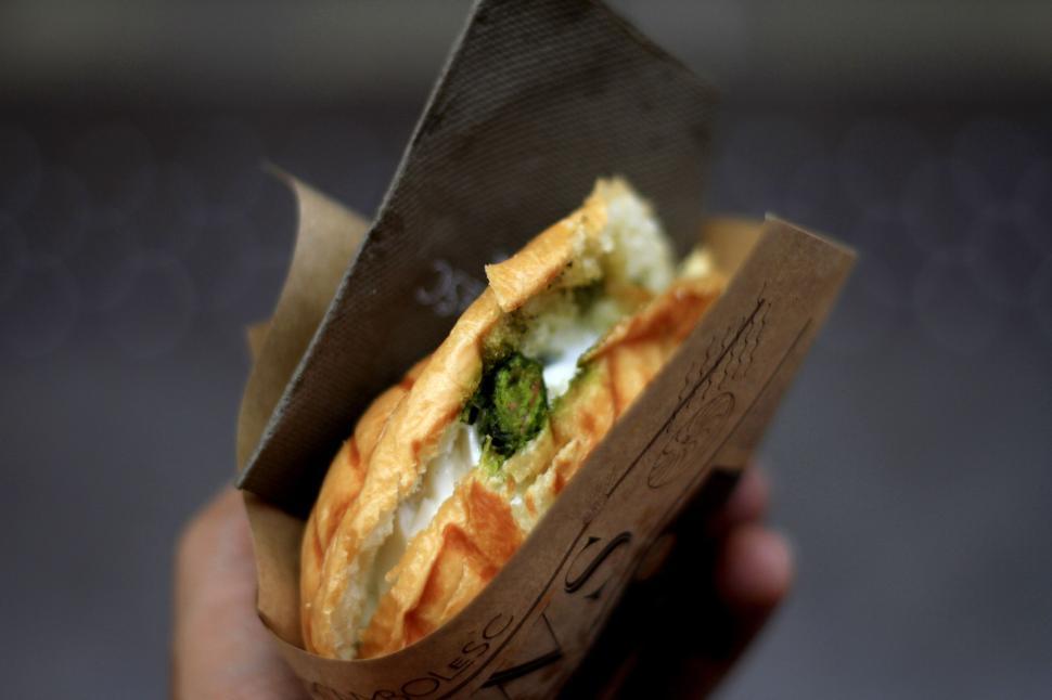 Free Image of Close-up of a gourmet sandwich with cheese and greens, street food 