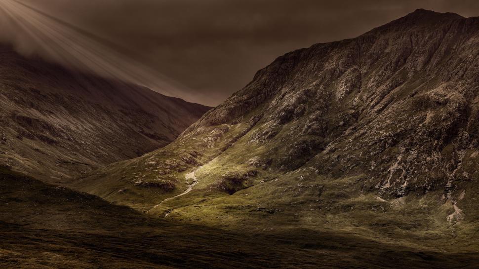 Free Image of Sunlight breaks through clouds on majestic mountainscape valley 