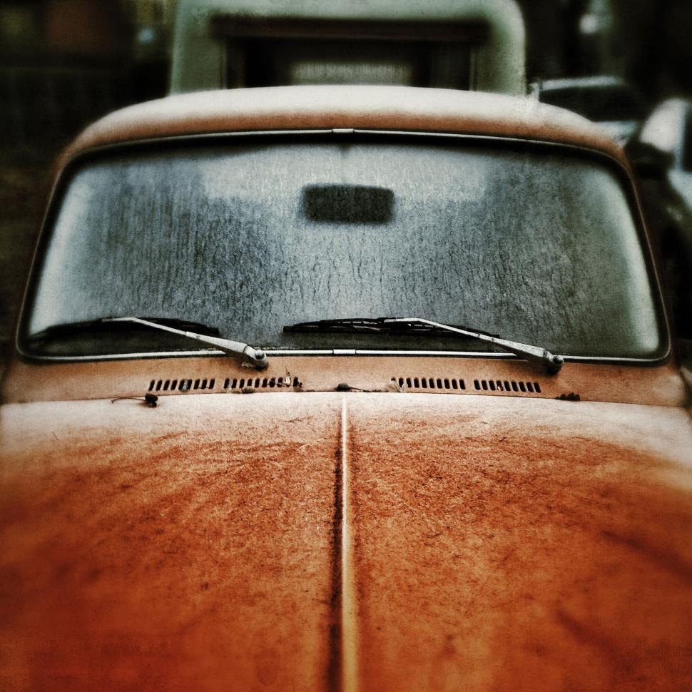 Free Image of Vintage rusted car seen from the front in a nostalgic setting 