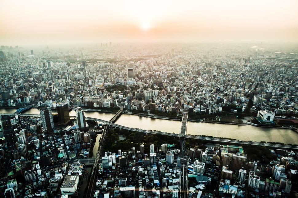 Free Image of Vast panoramic view of a cityscape with a river during sunset 