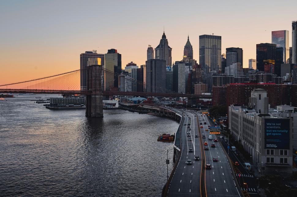 Free Image of Skyline at sunset with an iconic bridge over the river 