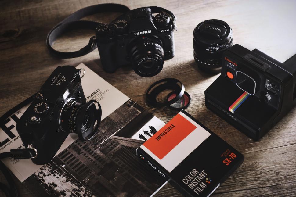 Free Image of Various vintage cameras and film on a wooden table for photography 
